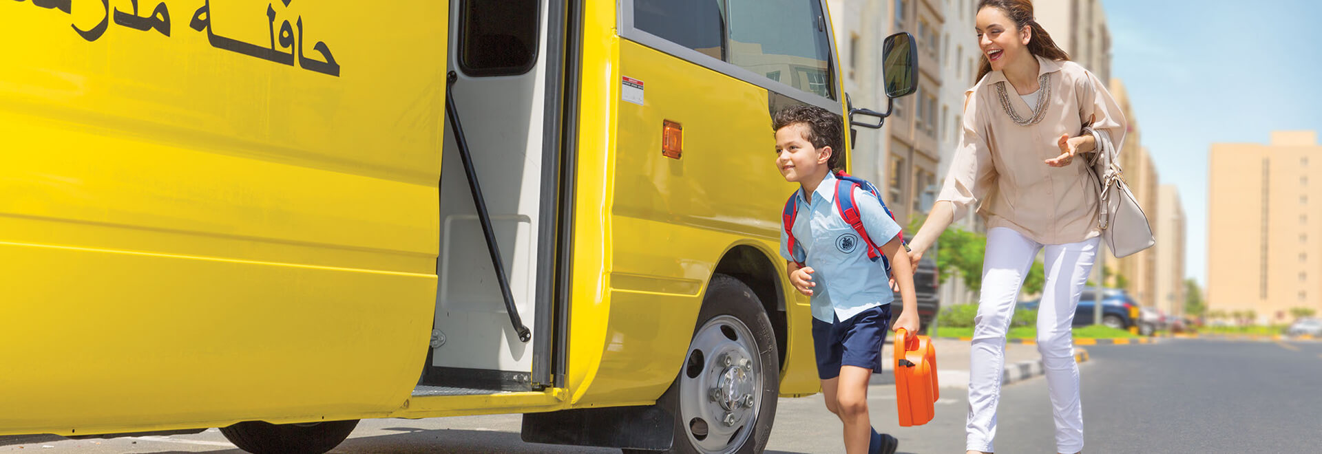 طالب مدرسي يستقل الحافلة في الصباح مع والدته 
